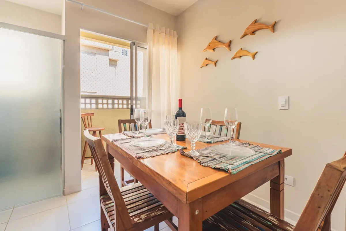 Mesa de jantar posta, com luz natural da sacada